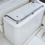White boat cockpit storage unit with a stainless steel guard rail and two circular hatch covers