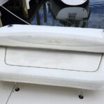 White marine bench seat on a boat deck with the Sea Ray logo on the backrest.
