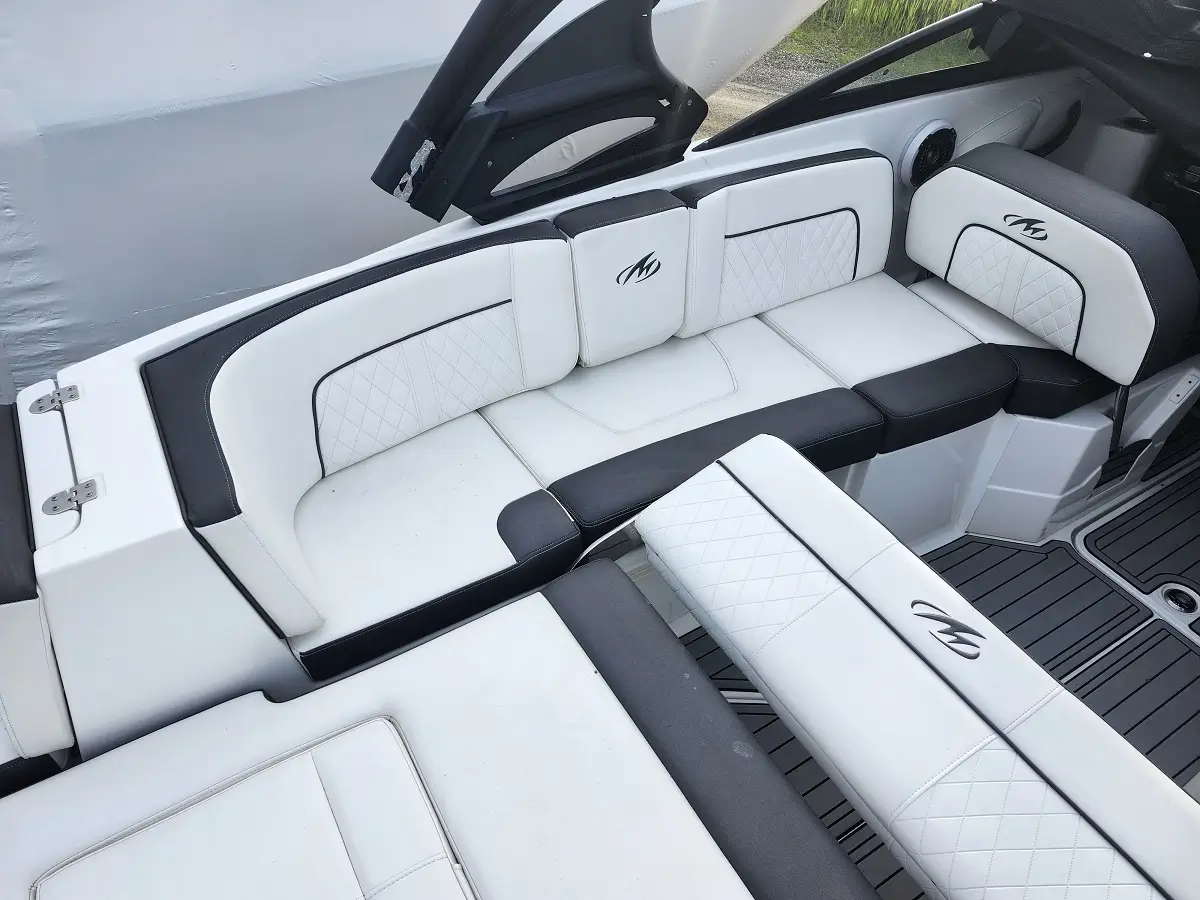 White and gray luxury boat seating with diamond quilting and logo embroidery, shown in a spacious cockpit area.
