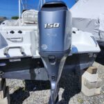 Rear view of a sport boat on concrete blocks with a large blue Yamaha 150 outboard engine mounted on the stern