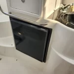 Norcold marine refrigerator panel built into a boat galley wall near a sink and counter.