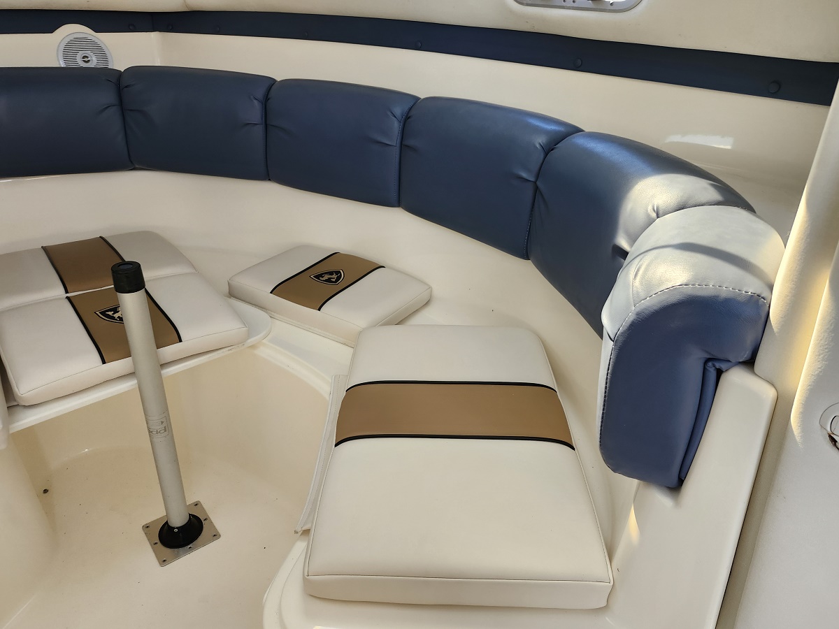 Curved white boat seating with blue back cushions and tan stripe cushions on a white deck.