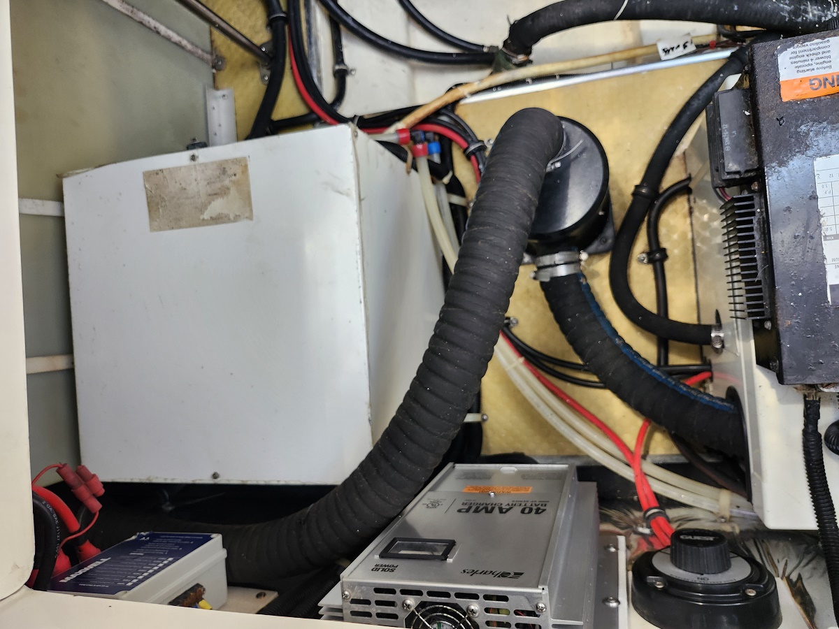 Electrical cabinet with thick black cables and a flexible conduit inside a utility panel.