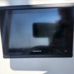 Garmin marine display mounted on boat with blank screen, reflecting the photographer's silhouette