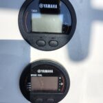 Close-up of a Yamaha boat dashboard showing a tachometer on top and a speed/fuel gauge below on a white panel.