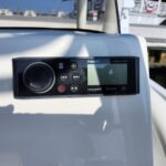 Fusion marine stereo on a boat dashboard with display screen and control buttons